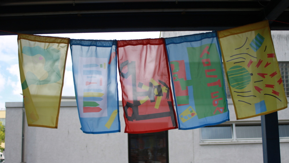 Fahnen zum Thema Freiheit wehende bunte Fahnen Gang zur GS Rastpfuhl