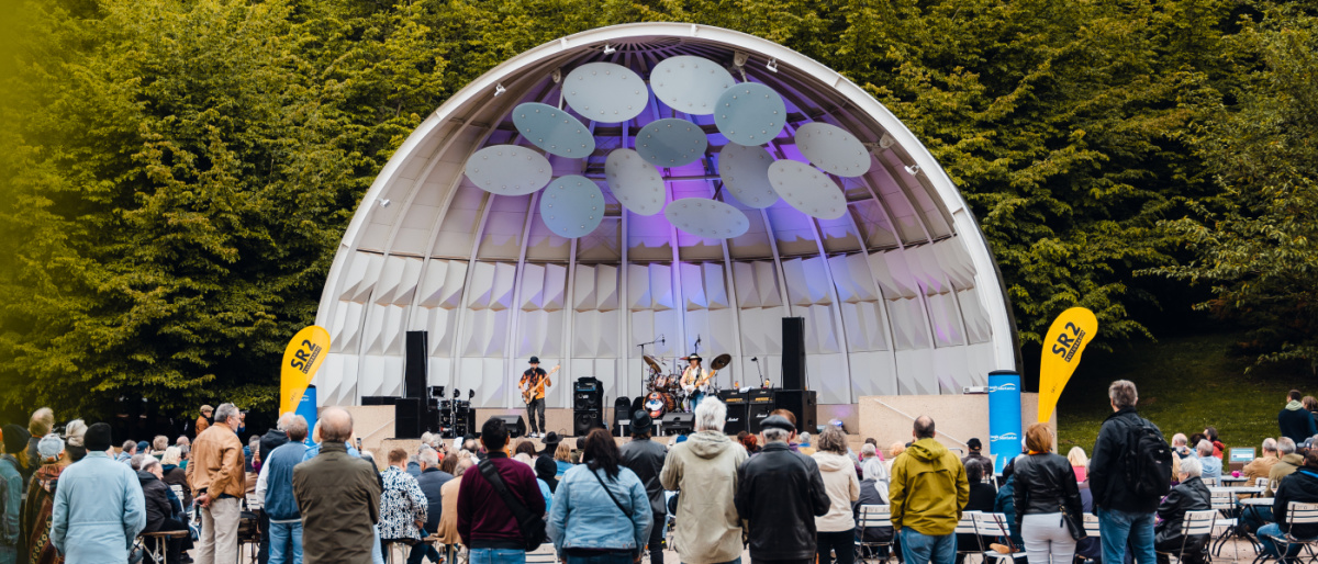 Zuschauende vor der Muschel mit Band im Deutsch-Französischer Garten