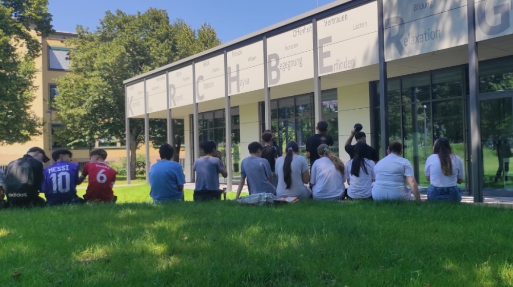Bilder Bildungswerkstatt Jugendliche sitzen vor der Bildungswerkstatt