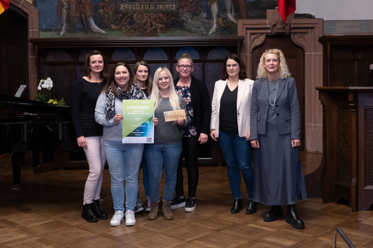 Kita Malstatt Preisübergabe an die Kita Malstatt. Zu sehen sind fünf Betreuerinnen der Grundschule, sowie zwei Jurymitglieder.