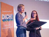 Carolin Cremer vom Stadtteilbüro Alt-Saarbrücken und Sandra Steinmetz beim Auftakt Demokratie leben 2025 zwei Frauen sprechen, eine hält ein Mikrofon
