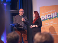 Asgar Abbaszadeh und Sandra Steinmetz beim Auftakt Demokratie leben 2025 ein Mann und eine Frau sprechen miteinander