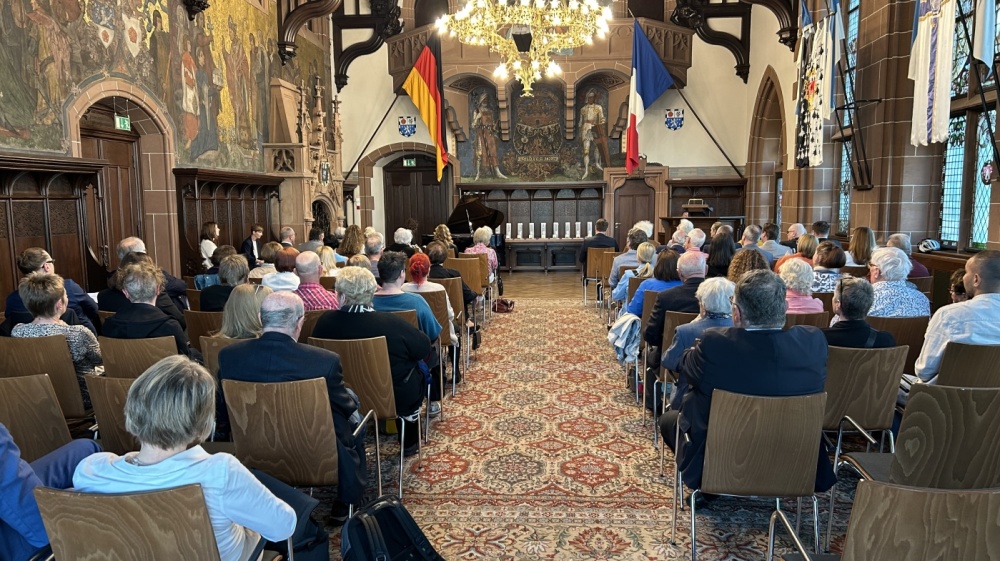 Rathausfestsaal Blick von hinten auf das Publikum im Rathausfestsaal mit ausgestellten Medaillen