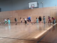 Kinder und Trainer beim Floorballtraining in Sporthalle 