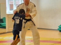 Kind und Judotrainer in Sporthalle