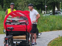 Fahrer warten vor roter Rikscha und unterhalten sich