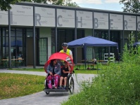 Rote Rikscha mit Kindern und Fahrern