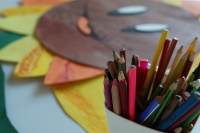 Fertiges Sonnenblumen-Kunstwerk auf Tisch ausgelegt; Becher mit Stiften