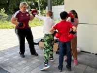 Boxtrainerin mit Kindern im Außenbereich der Bildungswerkstatt