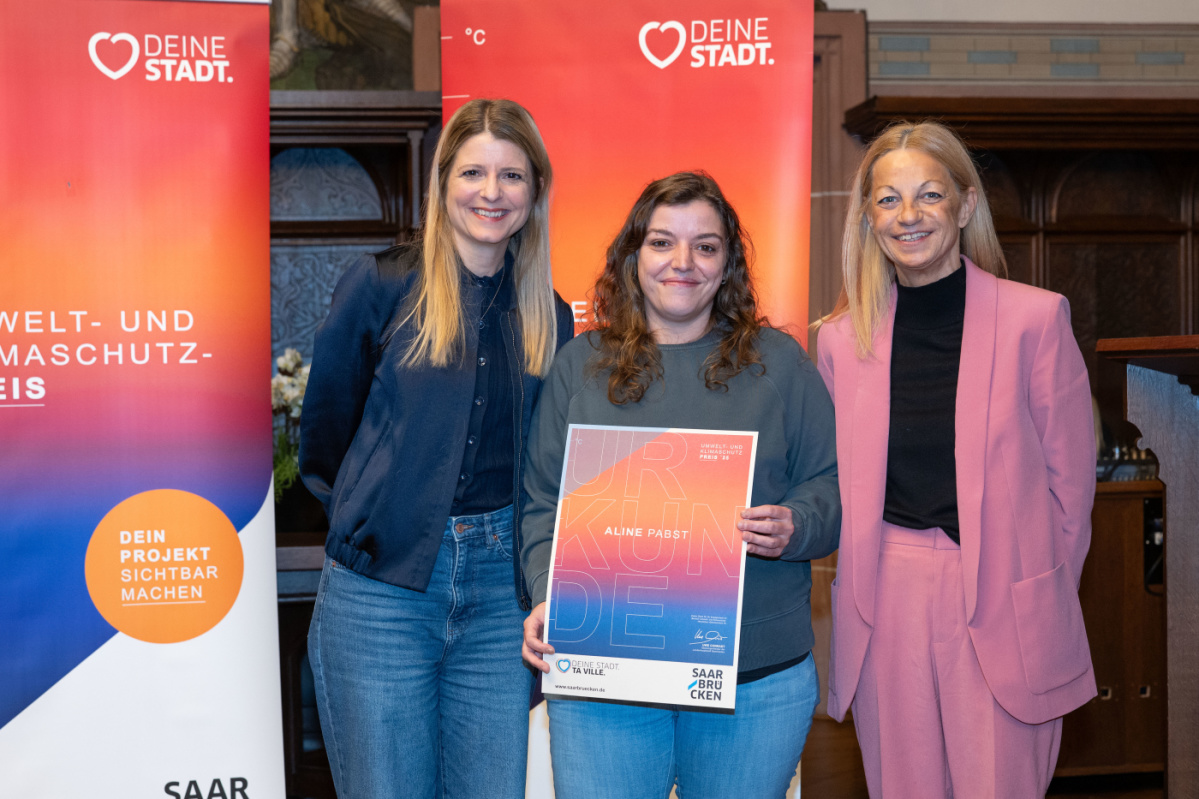 Sonderehrung - Aline Pabst Preisträgerin hält Urkunde in Kamera und lächelt