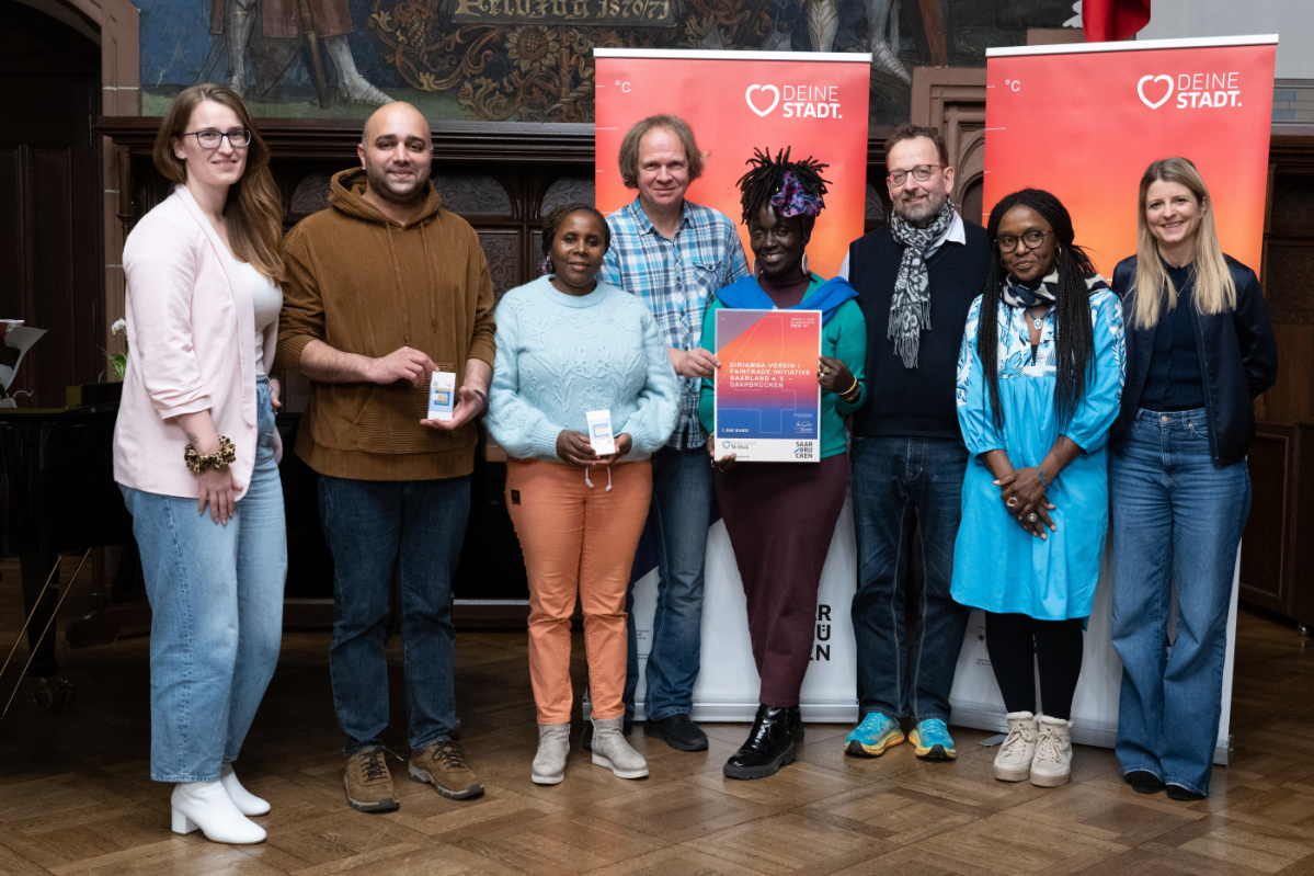 4. Platz - Diriamba Verein/ Fairtrade Initiative Saarland e. V. - Saarbrücken Preisträgerinnen und Preisträger halten Urkunde in Kamera und lächeln