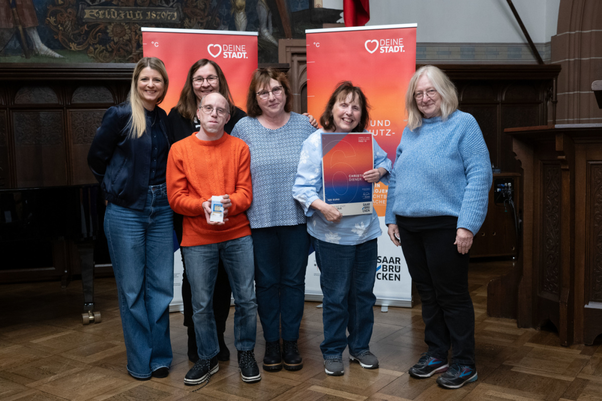 6. Platz - Christine Diener Preisträgerin und Begleitungen halten Urkunde in Kamera und lächeln