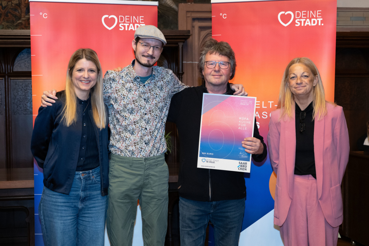 6. Platz - KÜFA (Küche für alle) Preisträger halten Urkunde in Kamera und lächeln