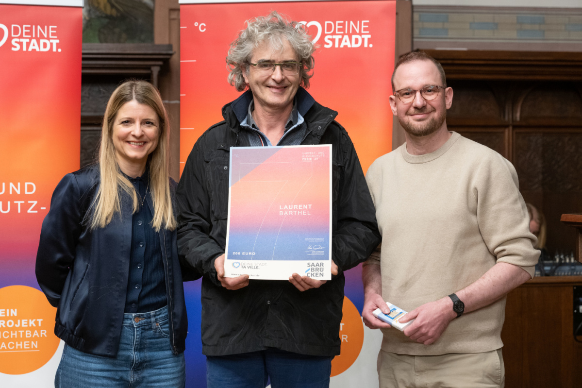 7. Platz - Preisträger Laurent Barthel Preisträger hält Urkunde in Kamera und lächelt