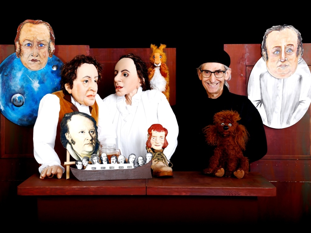Szene aus "Jean Paul" Menschen und Figuren stehen auf einer Bühne.