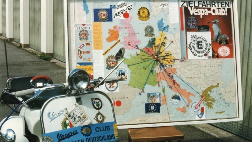 Geschmückte Vespa des Vespa-Clubs mit einer Landkarte im Hintergrund. Geschmückte Vespa des Vespa-Clubs mit einer Landkarte im Hintergrund.