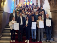 Gruppenbild auf der Rathaustreppe bei der symbolischen Übergabe der Förderbescheide