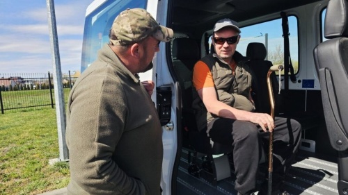 Minibus in Kowel Zwei Männer vor einem weißen Bus, einer davon mobilitätseingeschränkt