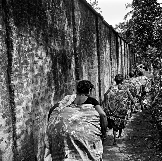 Frauen aus Bangladesh mit Waren an einer Mauer Grenze mit Indien
