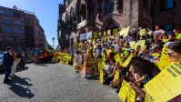 Menschen mit gelben Schildern vor dem Rathaus St. Johann