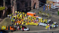 Menschen mit gelben Schildern vor dem Rathaus St. Johann